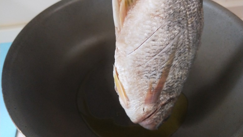 豆腐鱼头汤,放入鱼煎制。