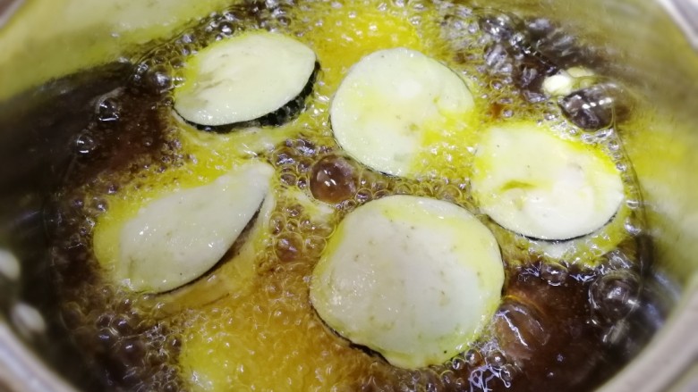 炸茄盒,轻轻放入油锅里,中小火炸一分钟。