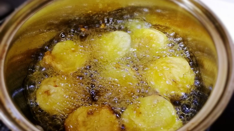 炸茄盒,全部炸好后,改中火油温高一点再复炸一遍,炸10秒上色捞出。