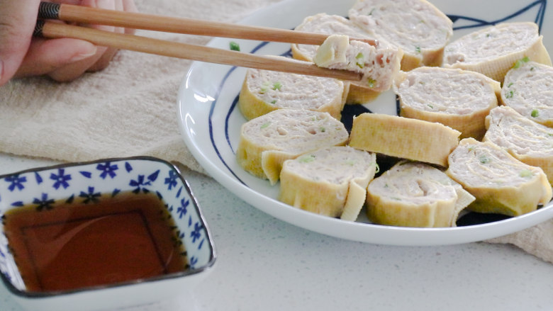 千张包肉,夹上一块,蘸上料汁,紧致的豆皮和嫩滑的肉馅结合,吃上一口,味道鲜美,唇齿留香