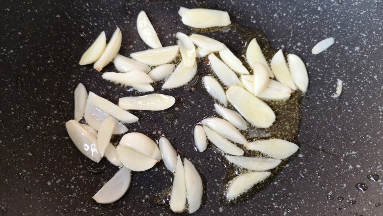 干煸豇豆,锅底留余油,下入蒜片。