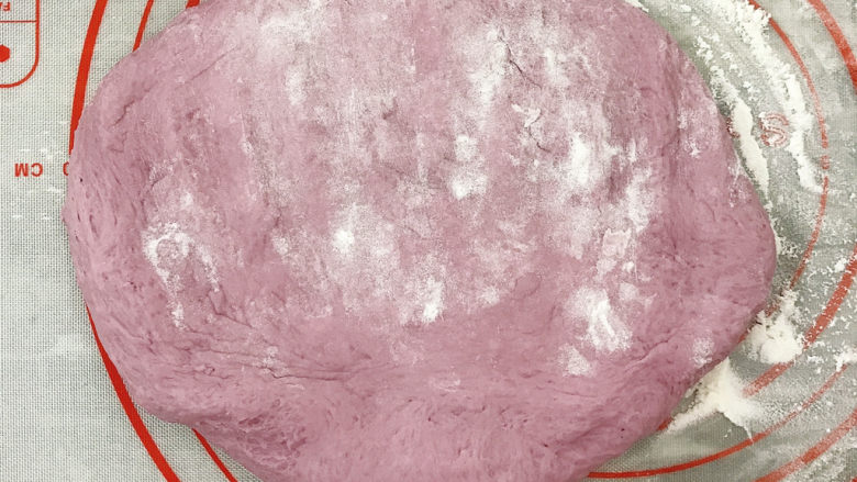 紫薯提子包,取出拍点干面粉压扁,揉搓排气,不需要排得太厉害,面包中留点空气口感会更好