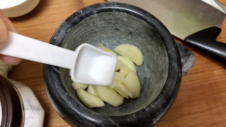 老北京炸酱面,取蒜臼,放入蒜,少许食盐