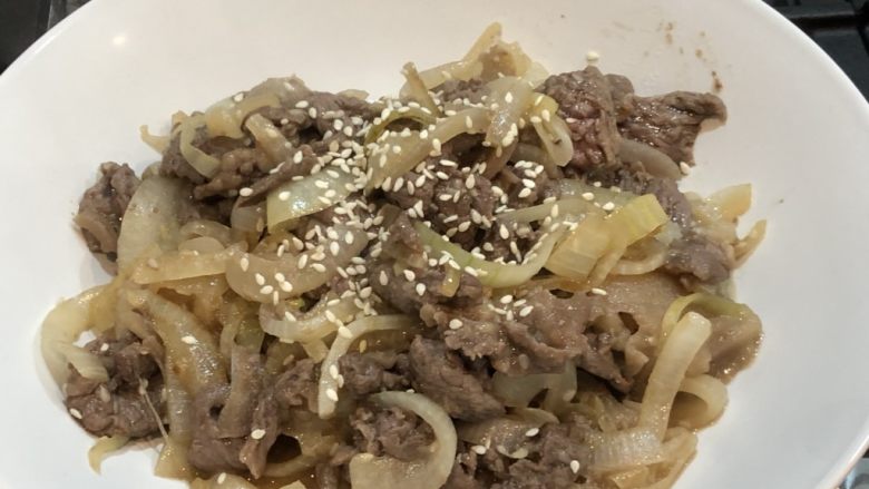 腊味煲仔饭,白菜味增汤,洋葱炒韩式牛肉,3.3 步骤三:牛肉炒好后,撒上些白芝麻。烤箱关掉。把这盘牛肉放进去,利用烤箱的余温来让这盘菜保持温度。这样一会等所有的菜都好了之后,也不会冷掉。