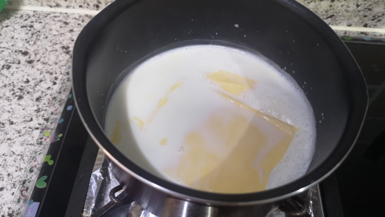 宝宝无糖奶酪棒,牛奶煮开了,转小火。这时就放芝士片,继续搅拌