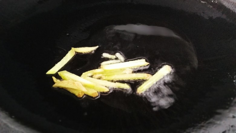 葱爆鱿鱼,热锅倒入适量油,放入生姜丝,文火炒香。