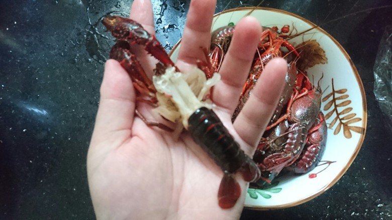 爆炒小龙虾,去头,除去多余部分,并捏住尾部中间抽出虾肠