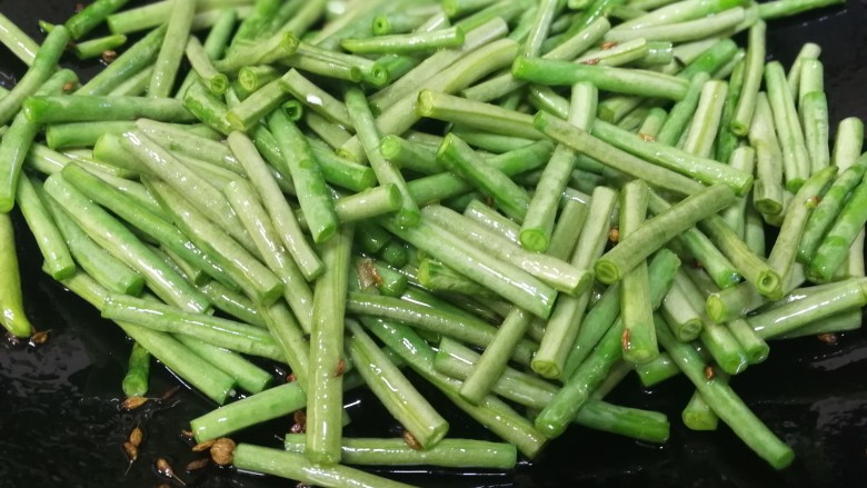 干煸豇豆,小火炒匀,把豇豆炒至变绿。