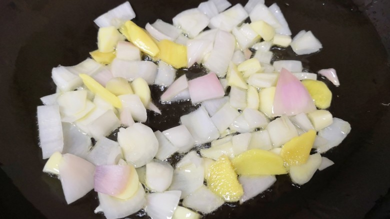 爆炒小龙虾, 炒锅内倒适量的食用油烧热,下入姜片、蒜片和洋葱炒香。