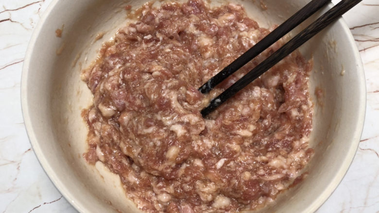 千张包肉,顺一个方向搅拌上劲,可以用4个筷子搅拌