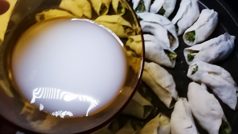韭菜锅贴,煎烤机预热 底盘刷一层食用油 将包好的锅贴胚码放盘中 加热1分钟 倒入淀粉水