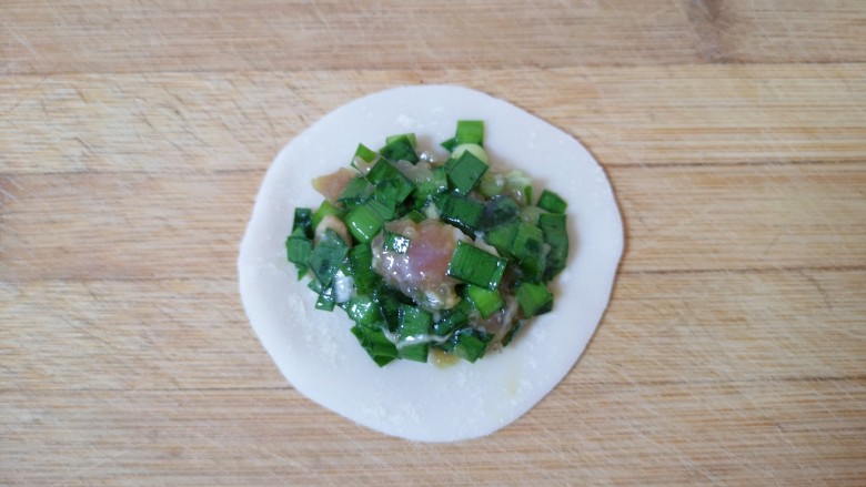 韭菜锅贴,取一个<a style='color:red;display:inline-block;' href='/shicai/ 4346'>饺子皮</a>放上韭菜肉馅(馅不要放太多,煎锅贴的时候容易漏出来)。