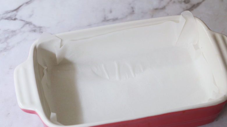 奶香蜜红豆年糕,取一个可以上锅蒸的容器,铺上油纸