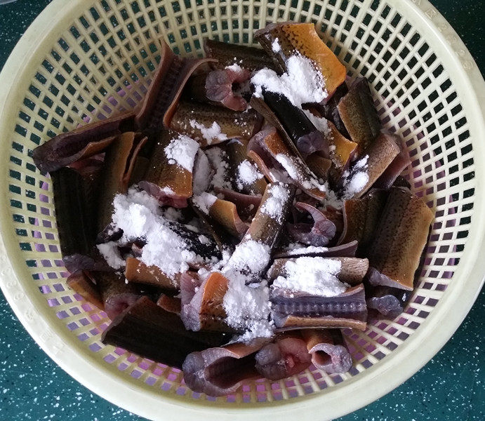 红烧黄鳝,撒上少许淀粉,抓起篮子摇一摇,让淀粉均匀地包裹鳝鱼表面,放一旁备用