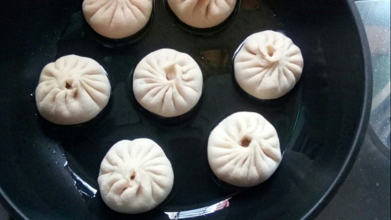 牛肉圆葱生煎包,平底锅倒油,放入包子,小火煎。