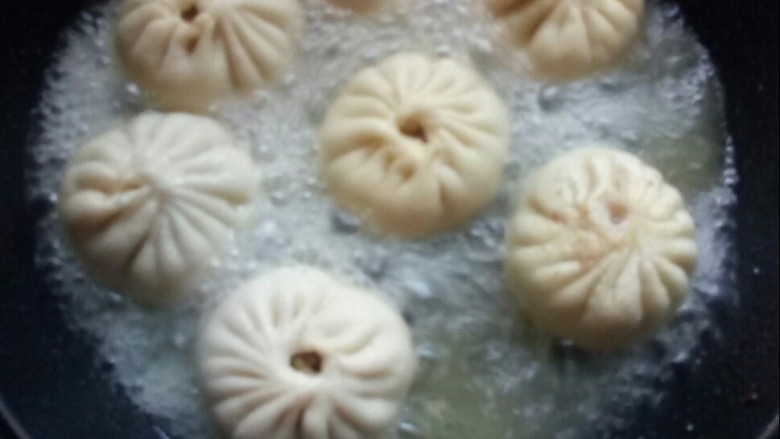牛肉圆葱生煎包,倒入高汤,加盖,大火焖。