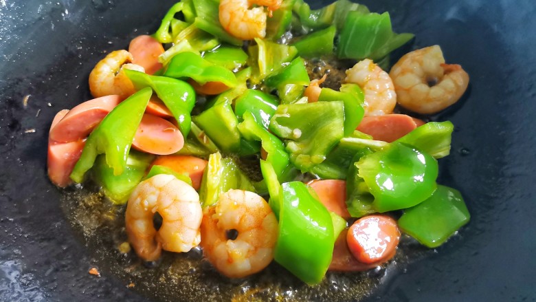 黑椒虾仁炒乌冬面,加入切好的火腿,青椒炒熟,