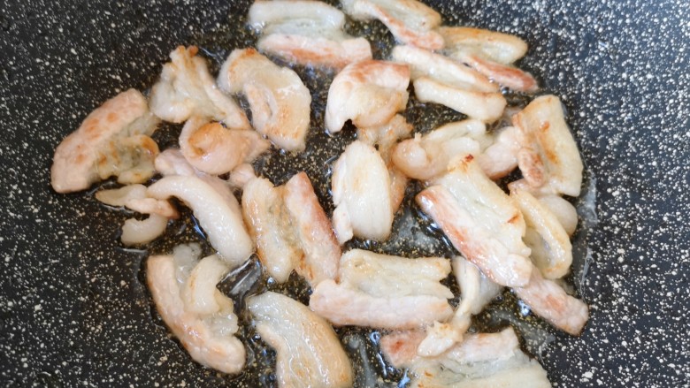 干锅千叶豆腐,锅底留余油,下入肉片炒出油脂。