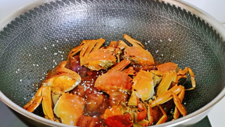 油焖大闸蟹,10分钟后蟹好啦,大火收汁至浓稠,撒上白芝麻关火出锅。