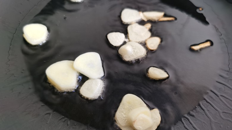 白玉菇鸡蛋汤,锅中烧热放油,加入蒜片,炒出蒜香味。