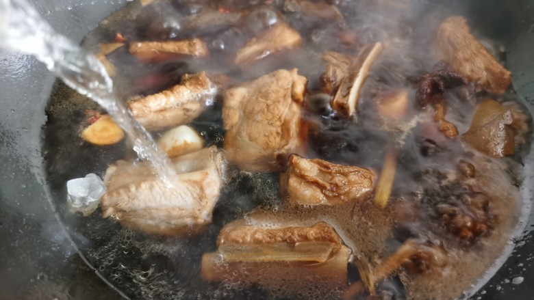 排骨焖面,倒入热水,水可以一次性多放一点。防止炖排骨过程中水分蒸发,到焖面的时候汤汁所剩不多。