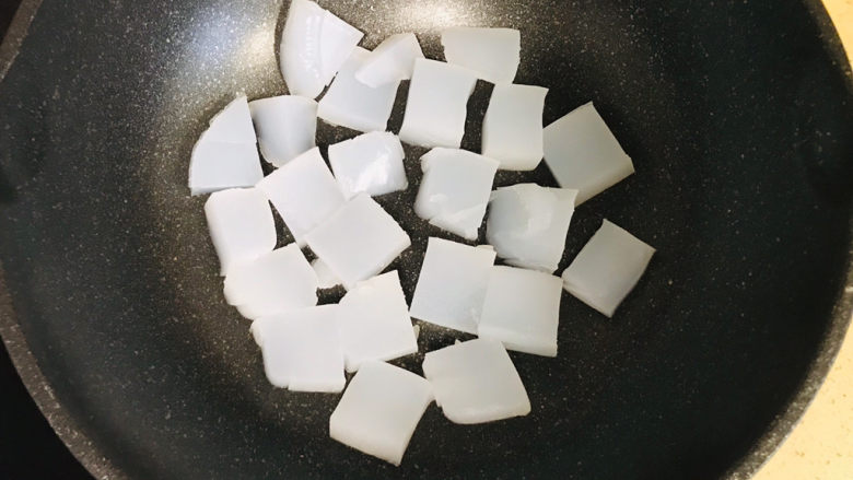家乡小吃—焖子,不粘锅烧热后,倒入适量的油烧热,将凉粉码放进锅里