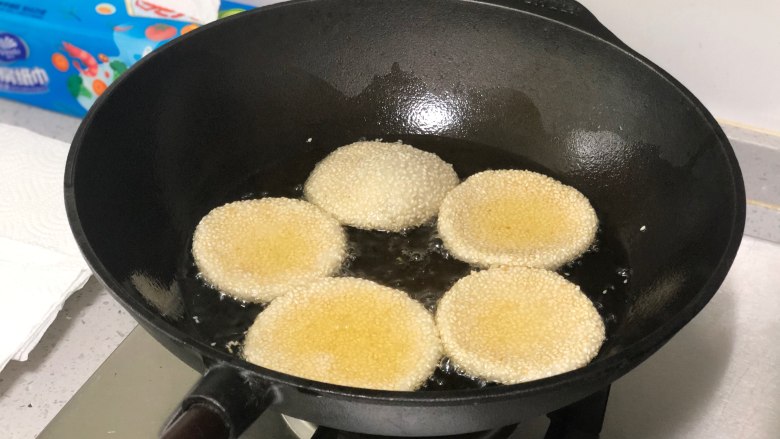 相传端午节吃“煎堆”能补天,既有嚼劲又香甜,小火加热到三成热,全程小火,放入芝麻饼,轻轻用漏勺拨动,防止粘在一起,煎堆会随着油温升高慢慢变大上浮。