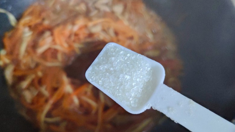 胡萝卜炒肉丝,待锅内汤汁差不多收紧,加一小勺细砂糖