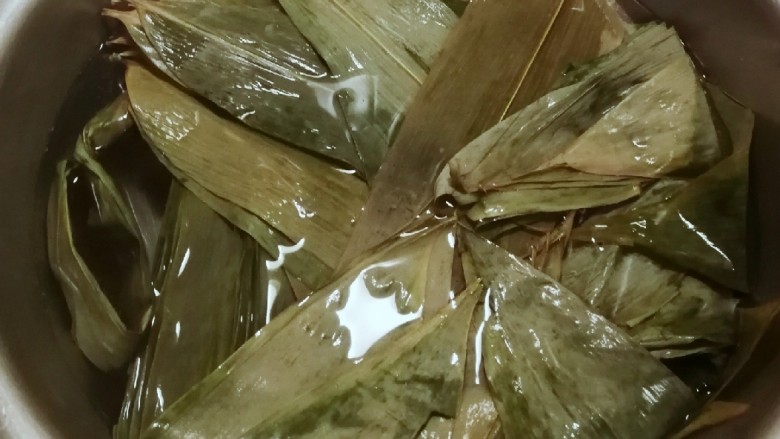 红豆粽子,干粽叶清洗干净水煮至粽叶变软,关火之后泡在水里 备用。