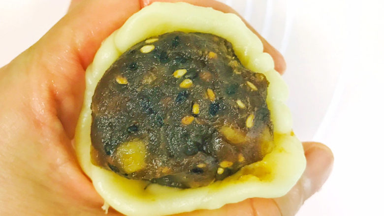 枣泥核桃馅老婆饼,取一个枣泥核桃球放在圆皮中间,利用左手的虎口,慢慢包起来