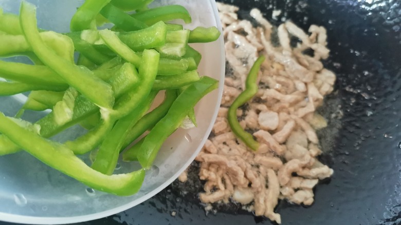 胡萝卜炒肉丝,肉丝炒至八分熟,倒入青椒翻炒