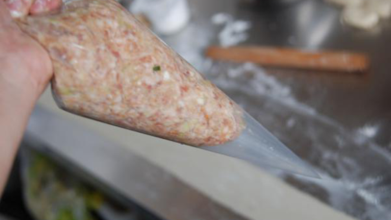 盘龙卷饼,拌好的肉馅装入裱花袋子中,前端剪开一个小口。