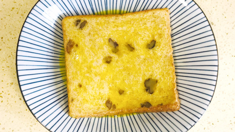 一个人的趣味早餐—笑脸吐司,翻过来再浸一下,使之正反两面全部浸湿,鸡蛋液均匀包裹住吐司片