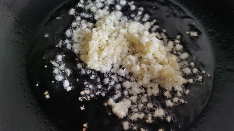 蒜蓉蒸丝瓜,炒锅放油,放入蒜末,用小火不停地翻炒。蒜末不要全部放入,留下一半待用。