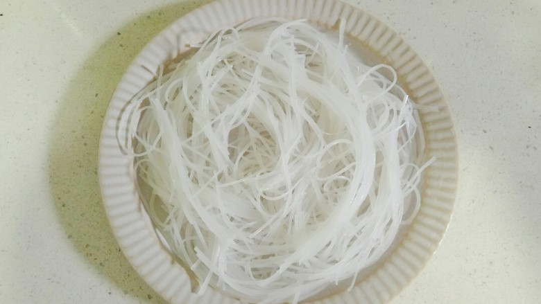 蒜蓉蒸丝瓜,将泡软的粉丝切小段,放在盘中