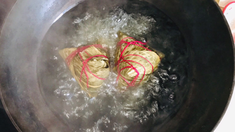 美味的新疆酸奶粽子,开锅后,用筷子把粽子翻个身,使之彻底煮透