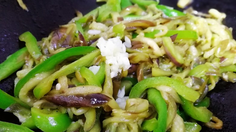 清炒茄丝,放入蒜末,简单翻炒一下即可。