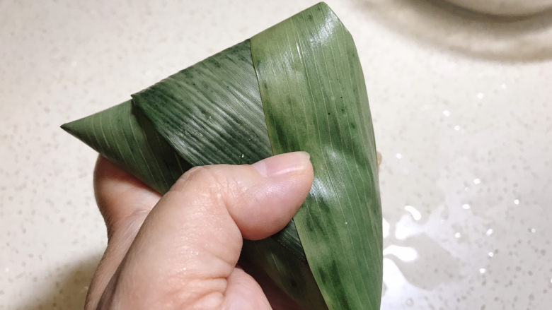 红豆粽子,多出来粽叶捏紧,折到一边