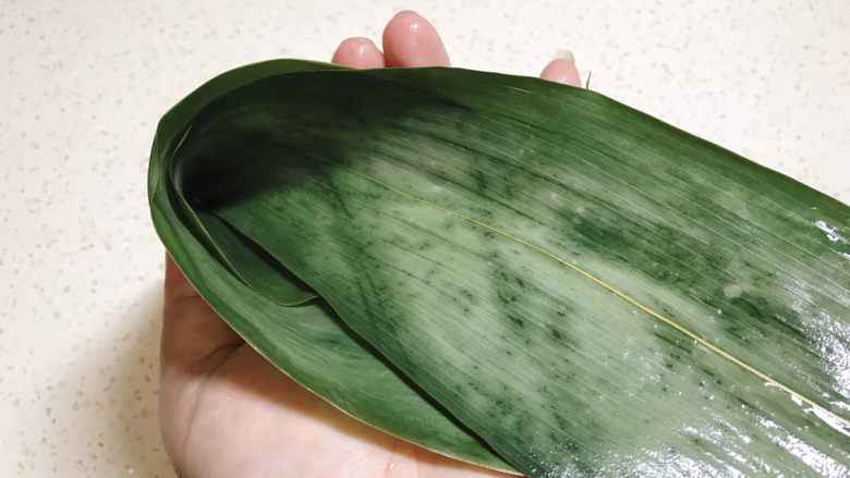 红豆粽子,然后从中间对折,掺一起,形成一个漏斗状