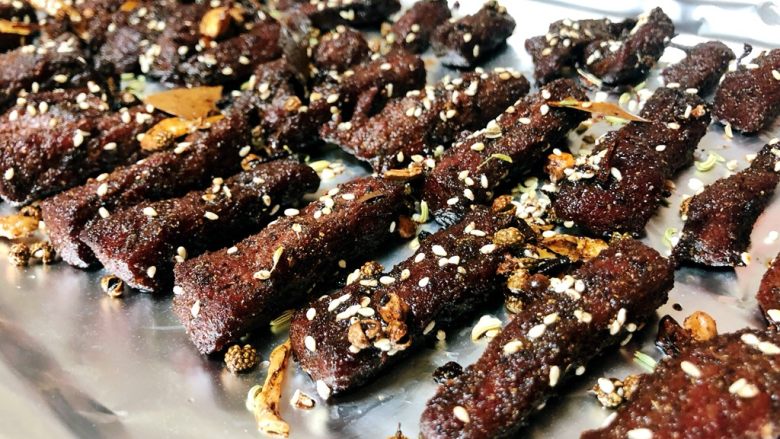 五香牛肉干,然后把炒好料的牛肉放入烤盘,烤箱预热5分钟