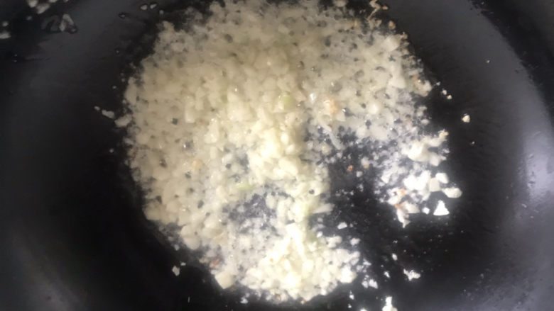 蒜蓉蒸丝瓜,油热下蒜末爆香,此时将火调小