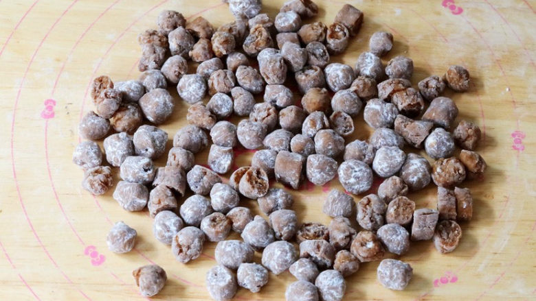 珍珠奶茶冻,将面团搓成长条,用刀切成丁,再搓成圆球状,表面撒上木薯粉防粘