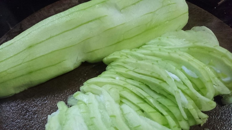丝瓜蛋汤,先对半切开,再切成半圆片