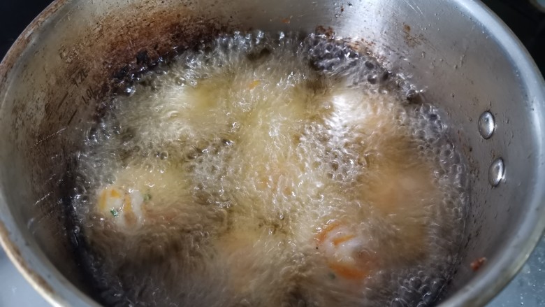炸胡萝卜小丸子,四周冒起大泡就差不多的温度。所有做好的丸子,放进去炸至外表变硬,微黄。