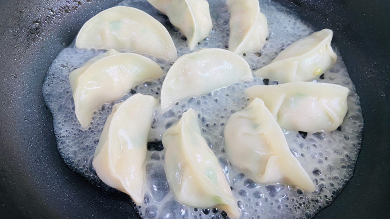 冰花锅贴,锅中的面粉水开始沸腾,盖上锅盖小火煎