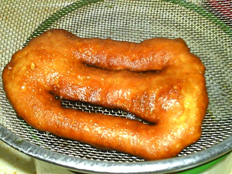 炸油饼,两面金黄,出锅,放入漏勺中控油。