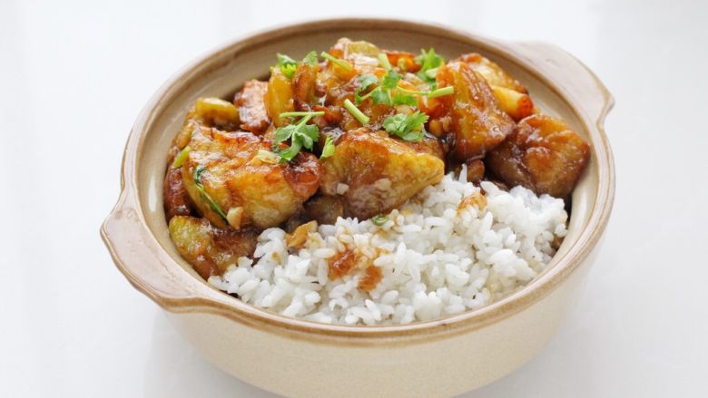 糖醋茄子盖饭,容器中盛入米饭,盛适量糖醋茄子盖在米饭上,吃的时候拌一拌就可以了。