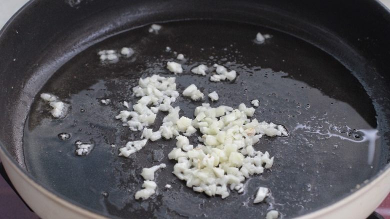 糖醋茄子盖饭,锅中留少许底油烧至五成热,放入蒜末小火炒出香味。