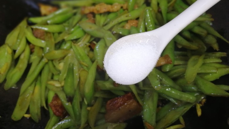 四季豆炒肉,放一小勺盐,文火炒匀。