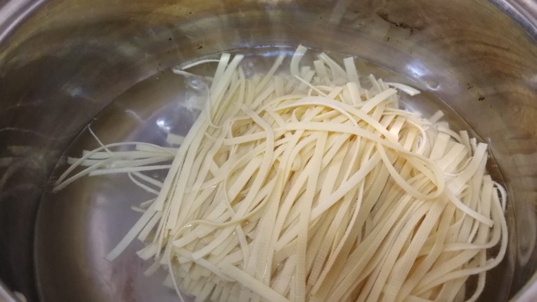 凉拌千张,水开放入千张丝,烫半分钟,增加千张丝的湿润度并去除豆腥味。